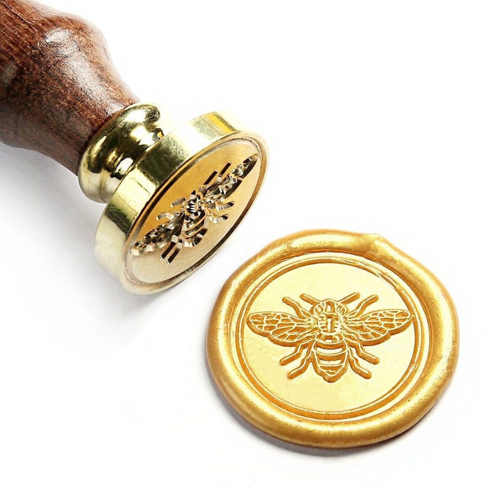 Image of a wax seal stamp and its seal, a honey bee. 