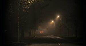 Image of a car driving down a dark road