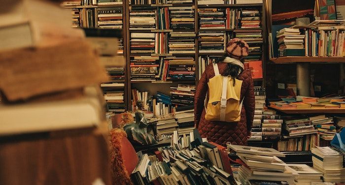 Image of a person in a hat browsing a used bookstore