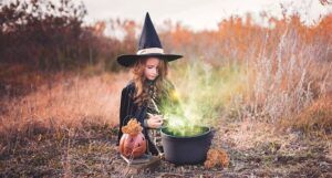 kid dressed up as a witch with cauldron