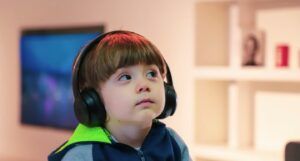 little boy sits with headphones on his head