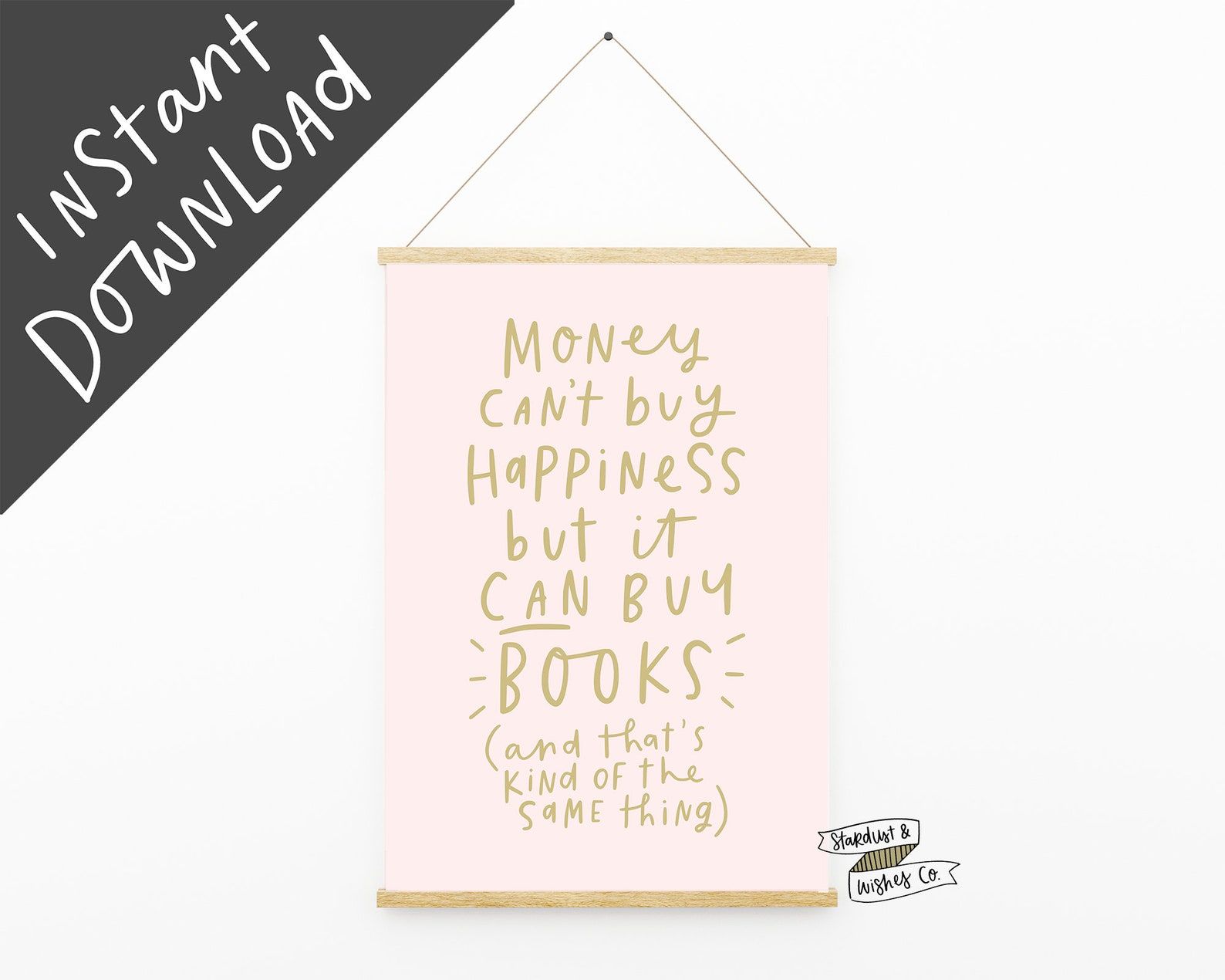 Image of a pink print with the words "money can't buy happiness but it can buy books (and that's kind of the same thing)" in gold. 