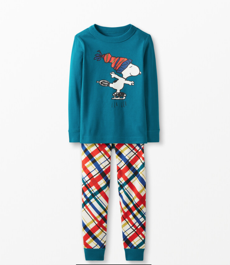 Chemise de pyjama bleue à manches longues représentant le patinage sur glace Snoopy, avec un pantalon de pyjama à carreaux rouge, bleu, jaune, rouge et blanc assorti.