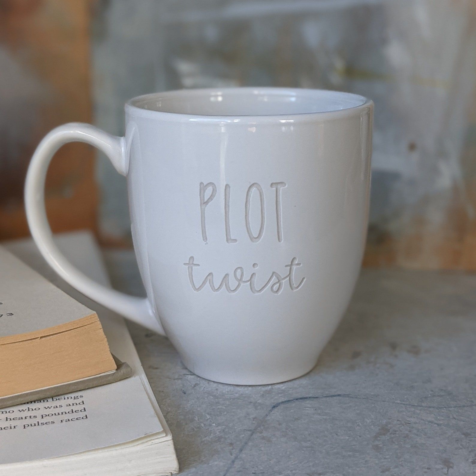 image of a white mug with the words "plot twist" engraved on it. 