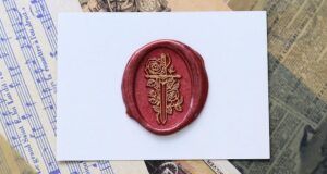 red wax stamp featuring a sword and roses