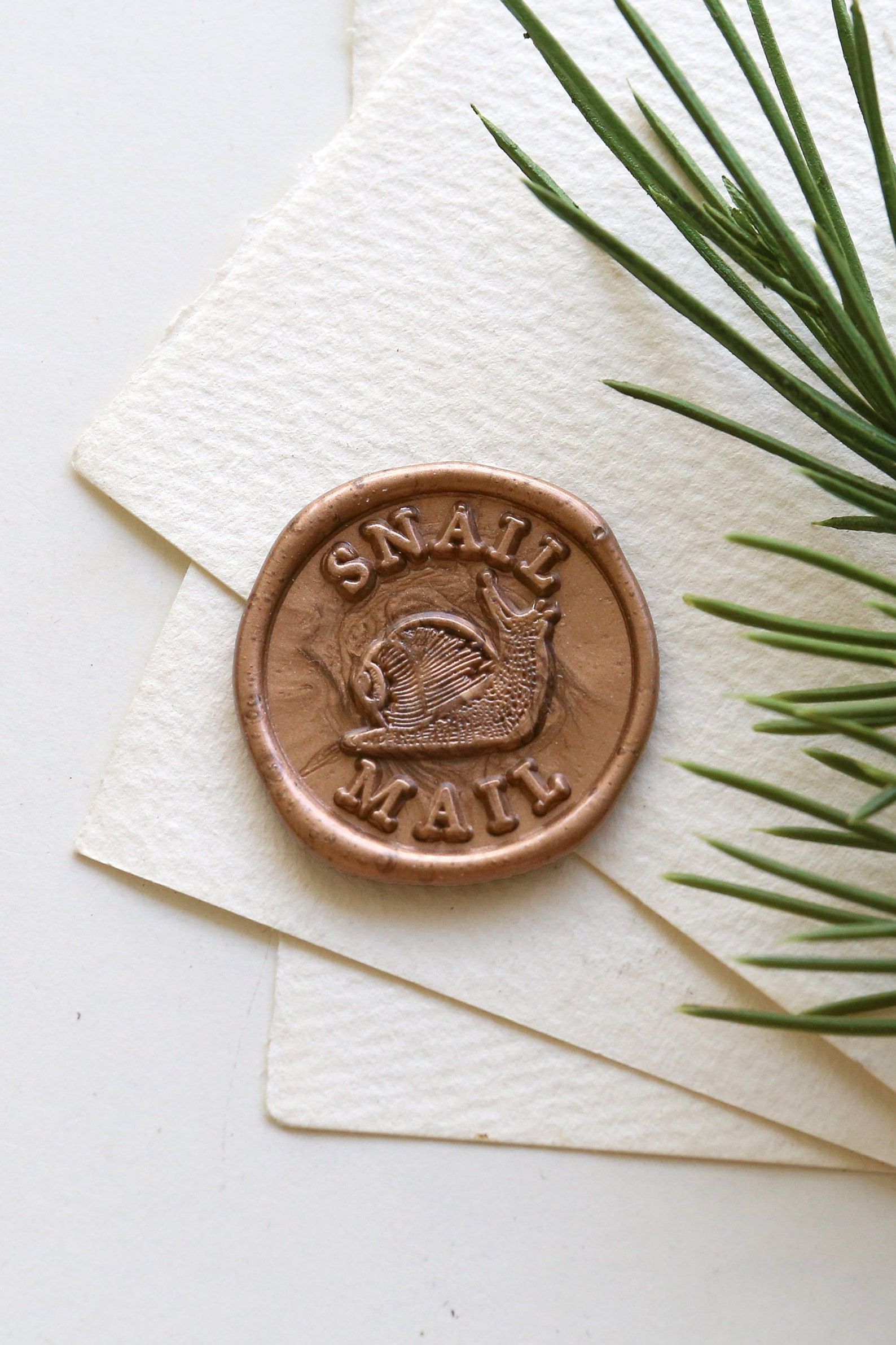 Image of a wax stamp. The center of the stamp has a snail, and the stamp reads 