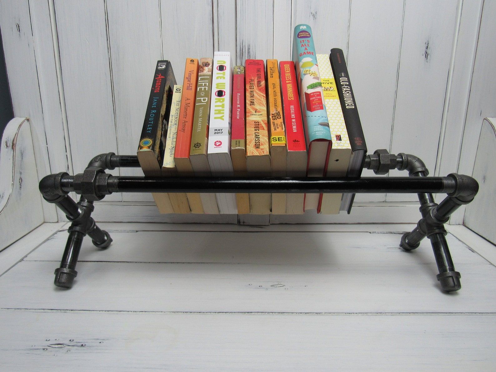 steel pipe book rack with books shelved in the center