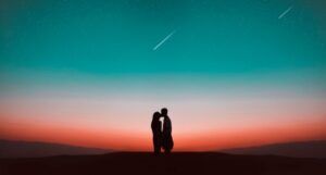 silhouette of a couple kissing in from of a sunset