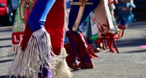 the legs of people doing a traditional Mexican dance in a parade