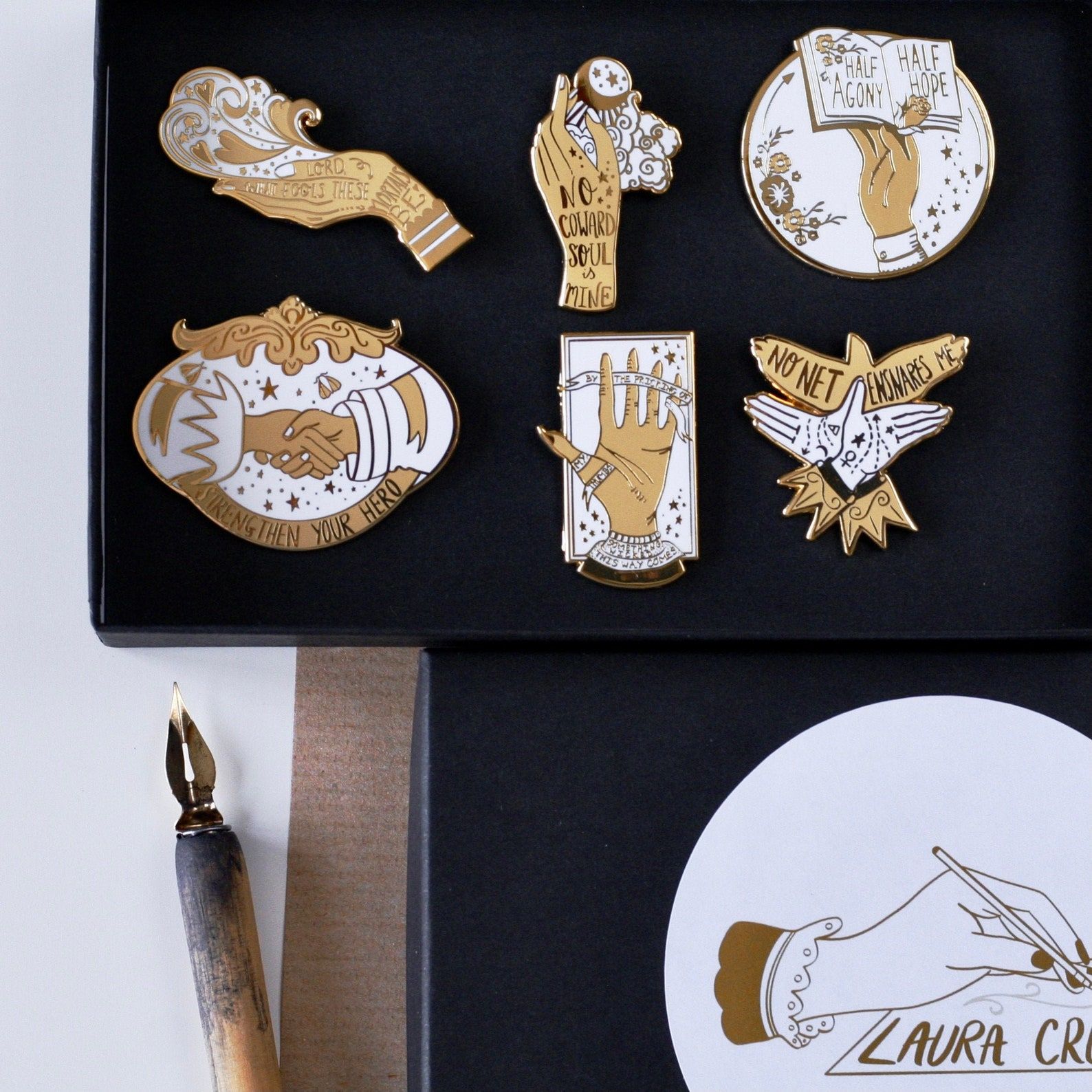 A set of six white and gold enamel pins featuring various illustrations of hands and florals, along with quotes from classic Victorian literature