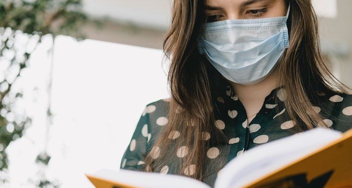 woman reading wearing mask