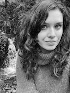 a black and white photo of Caitlin in front of a waterfall