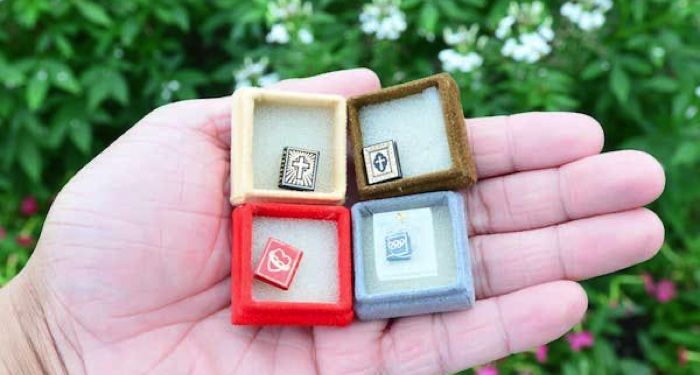 miniature books in the palm of a hand