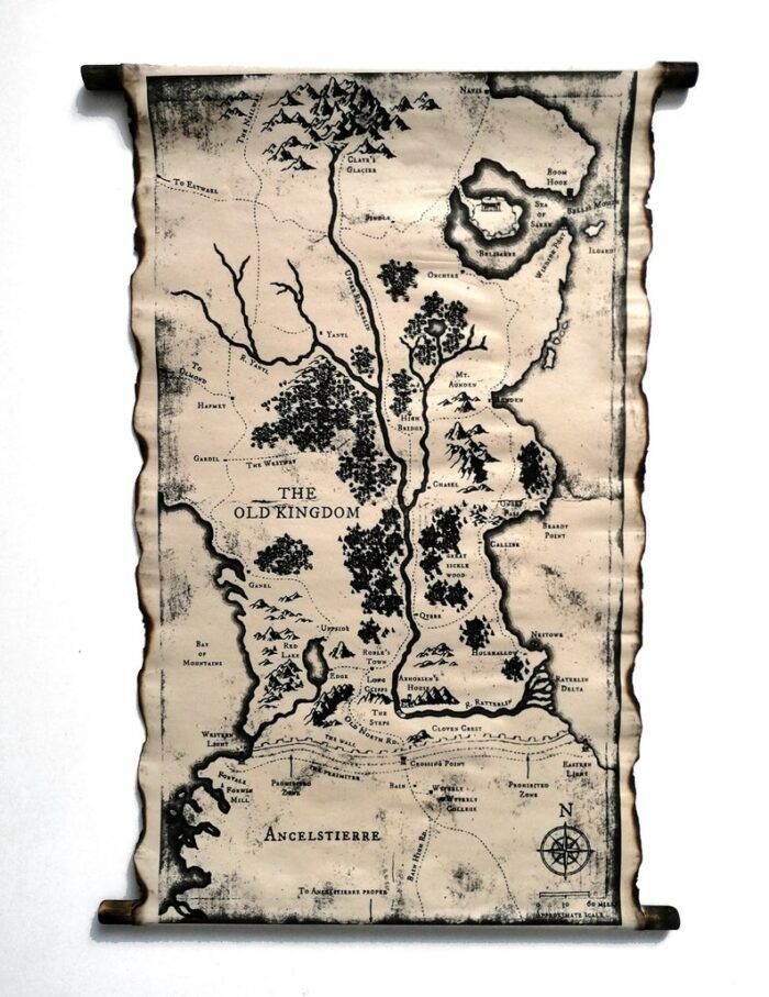 A scroll map of The Old Kingdom. The map features heavy geographical detail in black ink, with rivers and borders marked. The edges of the map are burnt and it is supported by two wooden ends. It looked yellowed and much aged.