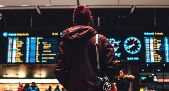 person standing in front of airport schedule