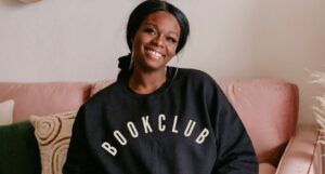 image of a Black woman wearing a black "book club" sweatshirt