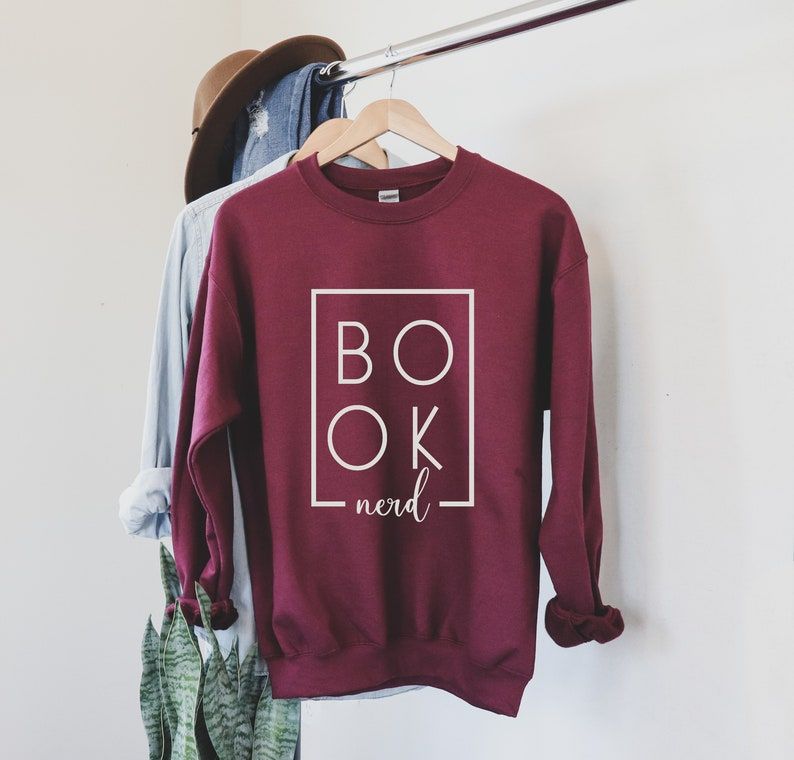 Image of a maroon sweatshirt. The white text features a box around the word "Book," which is broken into two lines. The box meets beneath the second line and has the word "nerd." 