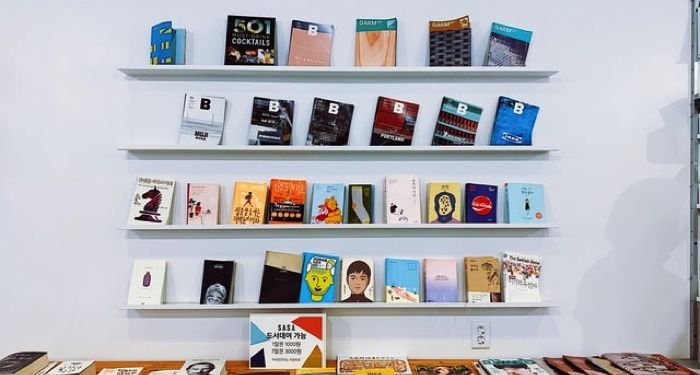 books on shelves against a white wall in a book store