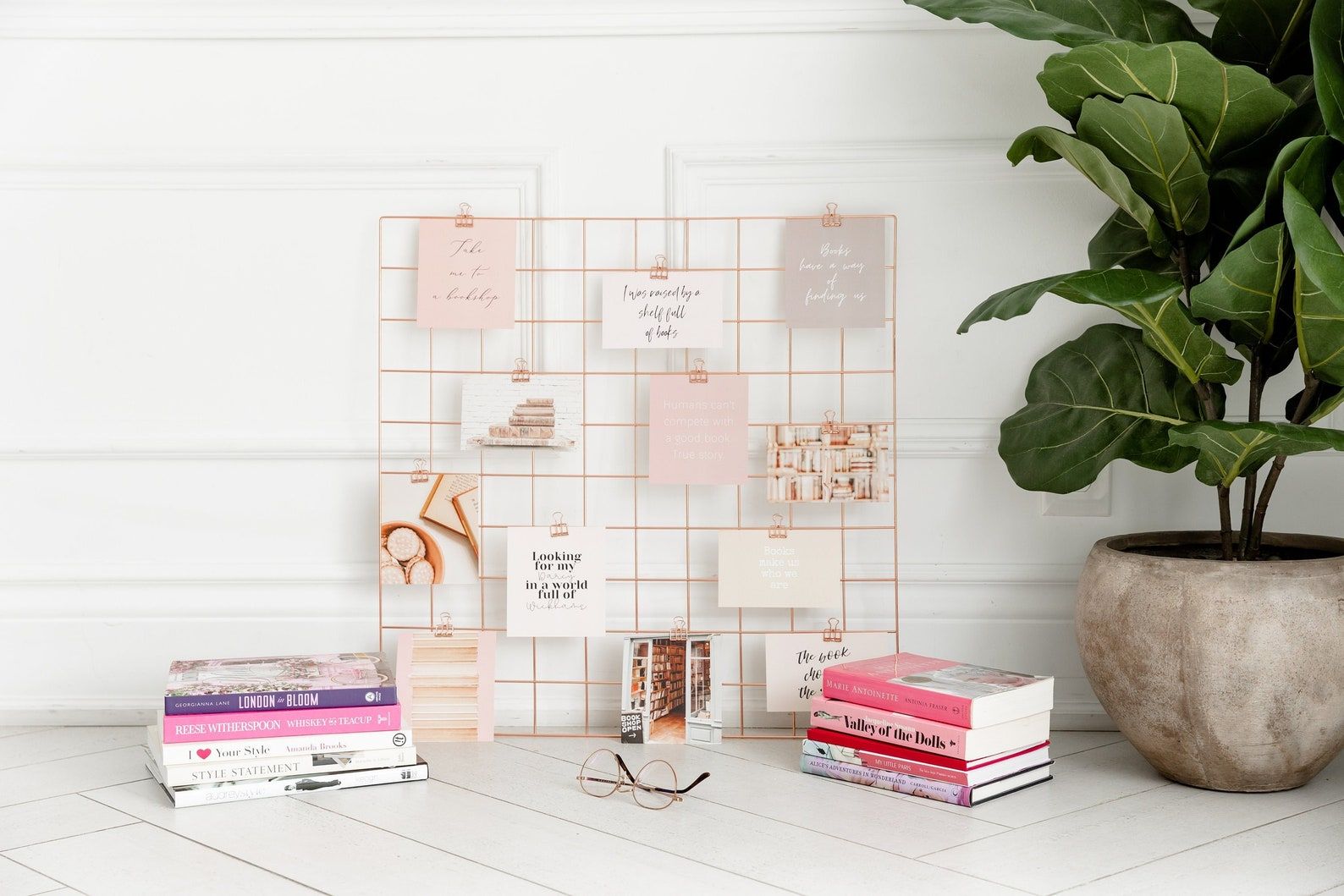 Image of a rose gold memo board, covered in small bookish notes and images. 
