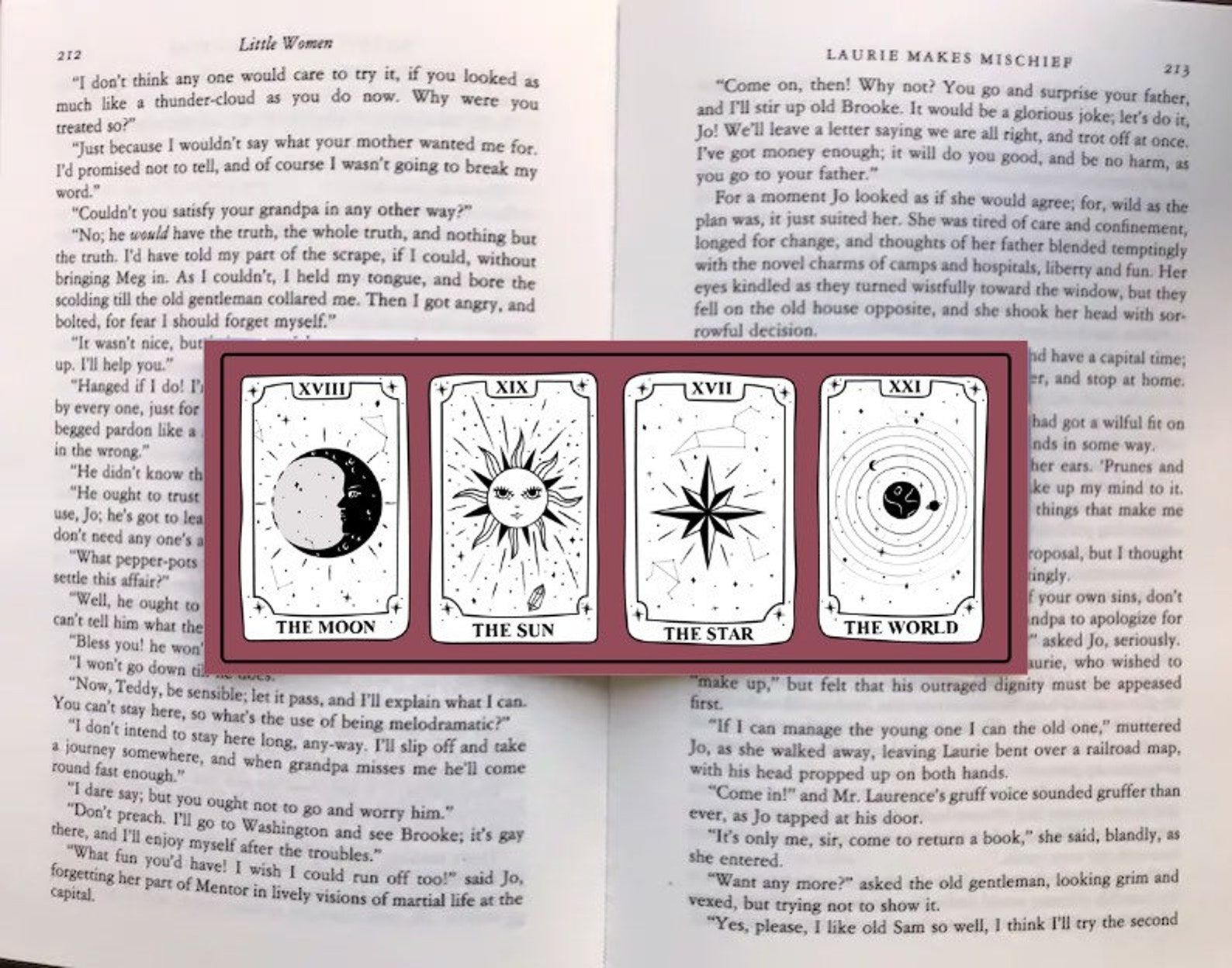 Image of a rose-colored bookmark on an open copy of Little Women. The bookmark features four tarot cards, all cream-colorred.