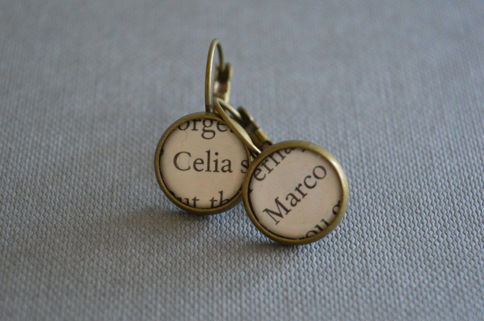 Two bronze earrings displaying the names Celia and Marco.