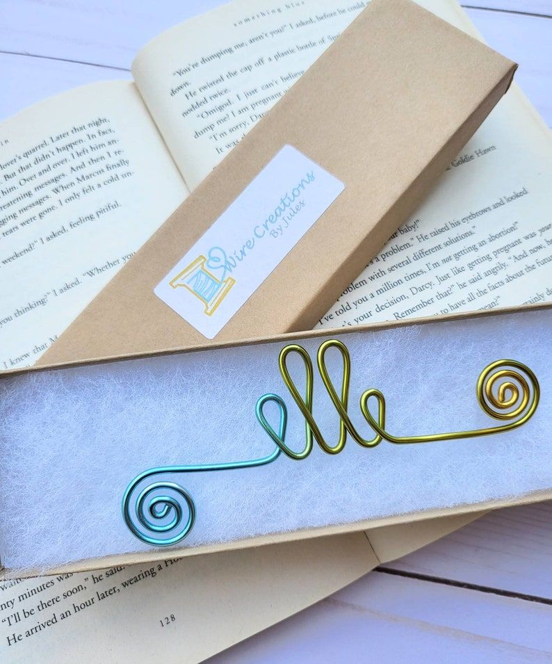 Image of a bookmark made of rainbow wire. It reads "Elle." 