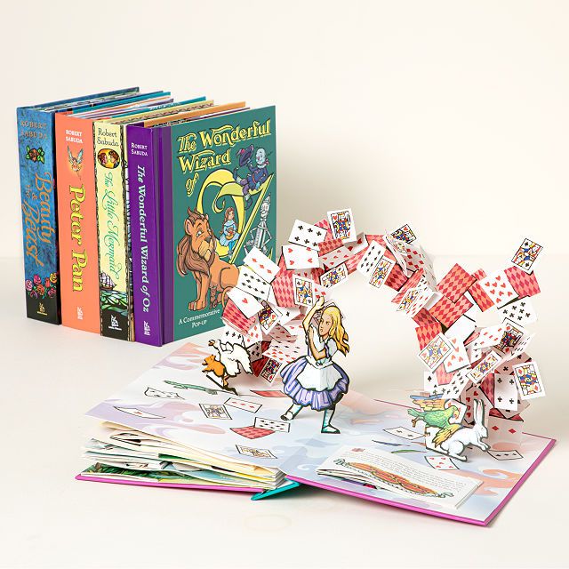 Collection de livres pop-up présentant des contes de fées.  Le livre ouvert devant l'image est pour Alice au pays des merveilles. 