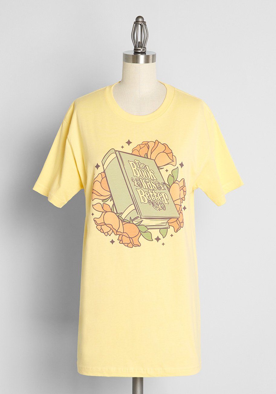 Yellow t-shirt with words "the book was better," on a green book with roses around it. 