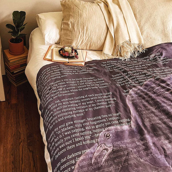 purple blanket with white lettering and image of a raven