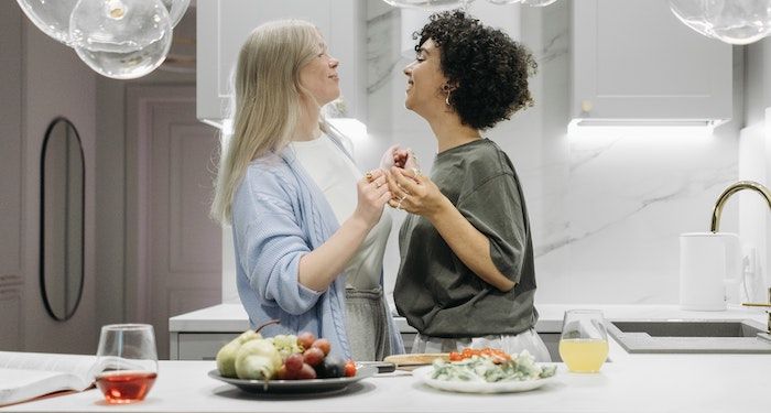 two women dancing and smiling in kitchen