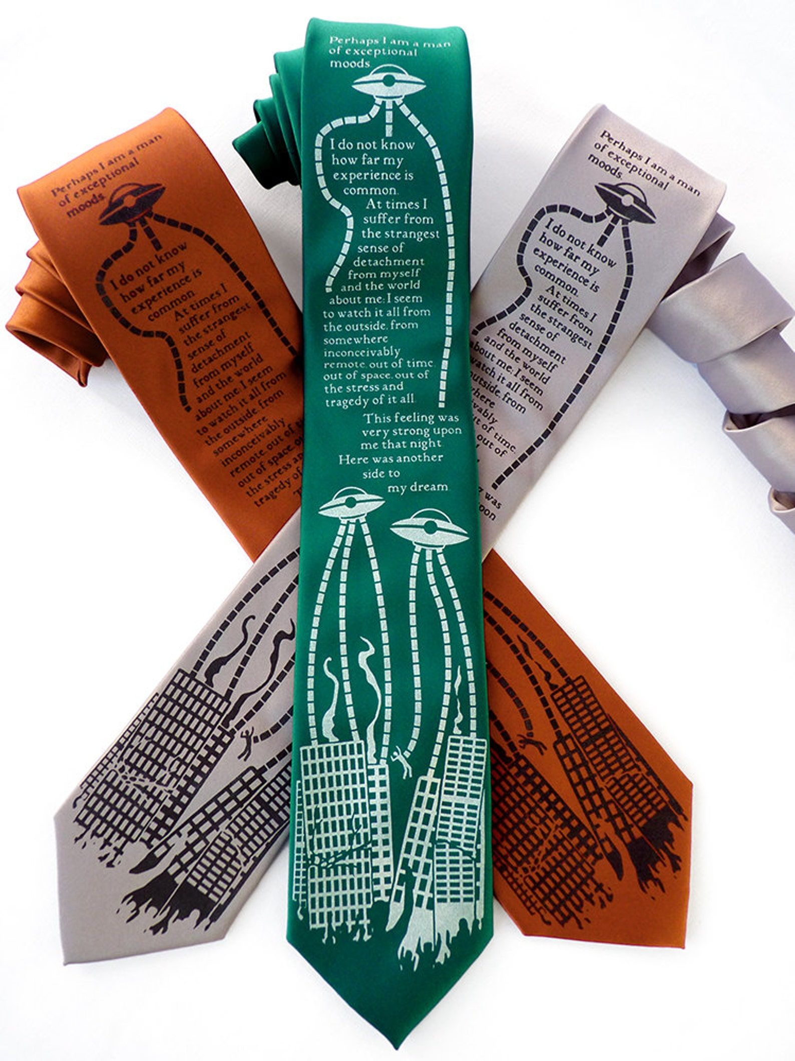 Three neckties in orange, green, and gray all depicting aliens from War of the Worlds with a quote from the book.