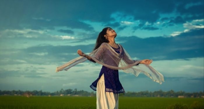 young woman frolicking in a field in India