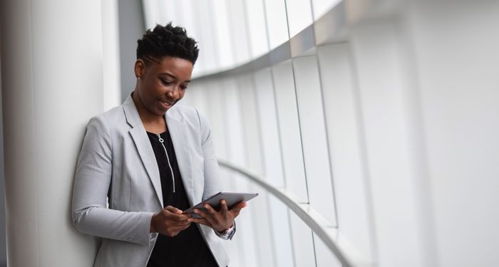 Black woman looking at a tablet