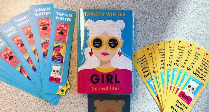 a photo of Girl (In Real Life) by Tamsin Winter with matching bookmarks displayed beside it