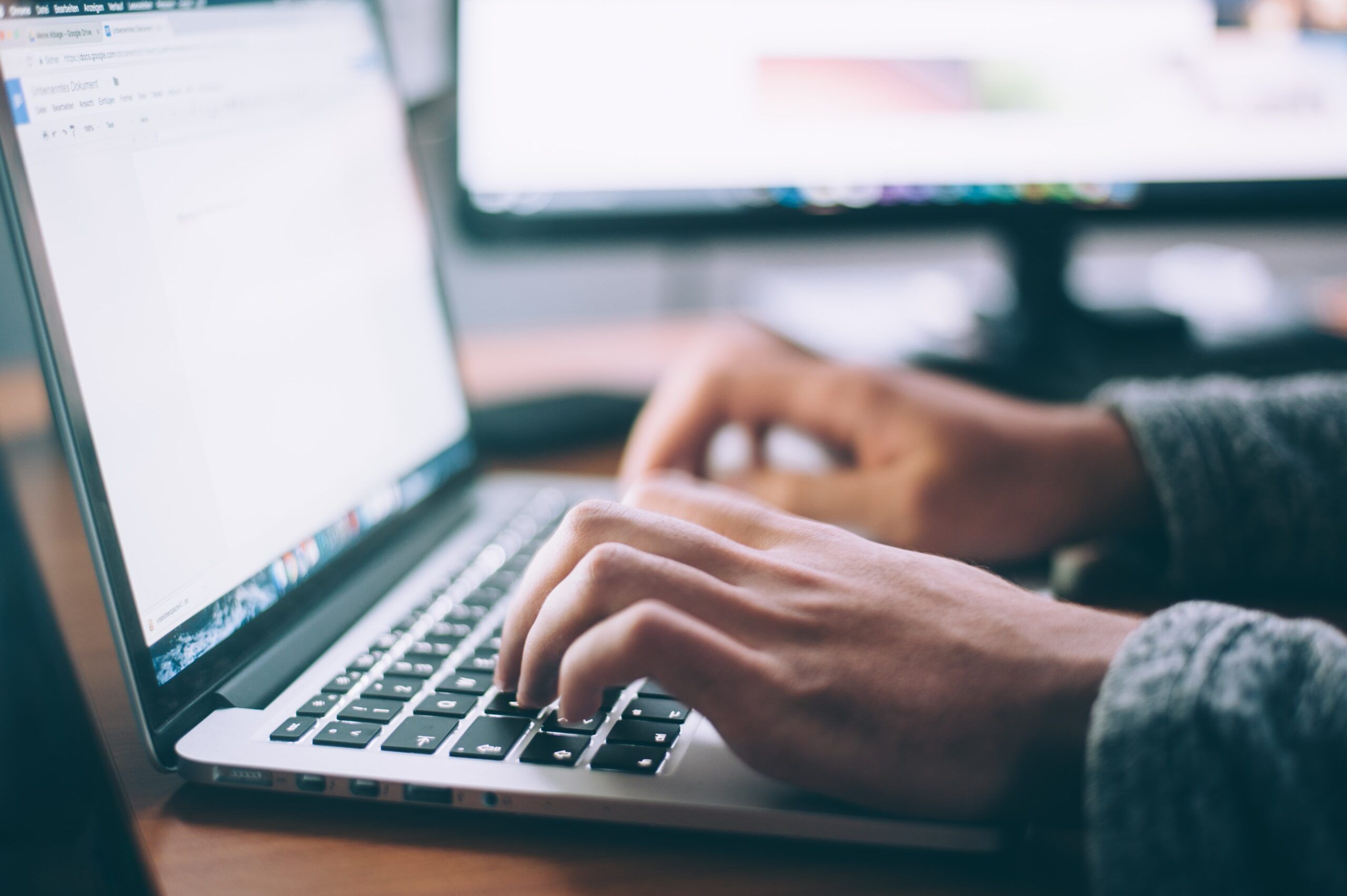 a photo of a person typing on laptop