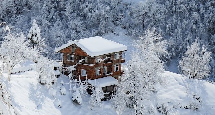 a photo of a snowy cabin on a mountain