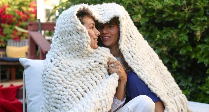 women cuddling under blanket
