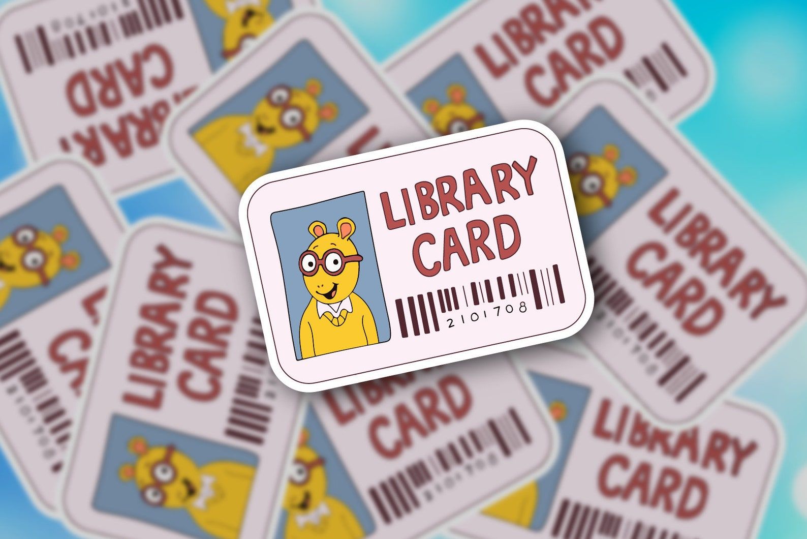 Image of a sticker in the shape of a library card. It reads Library Card, with a bar code below, and the image on the card is of Arthur. 