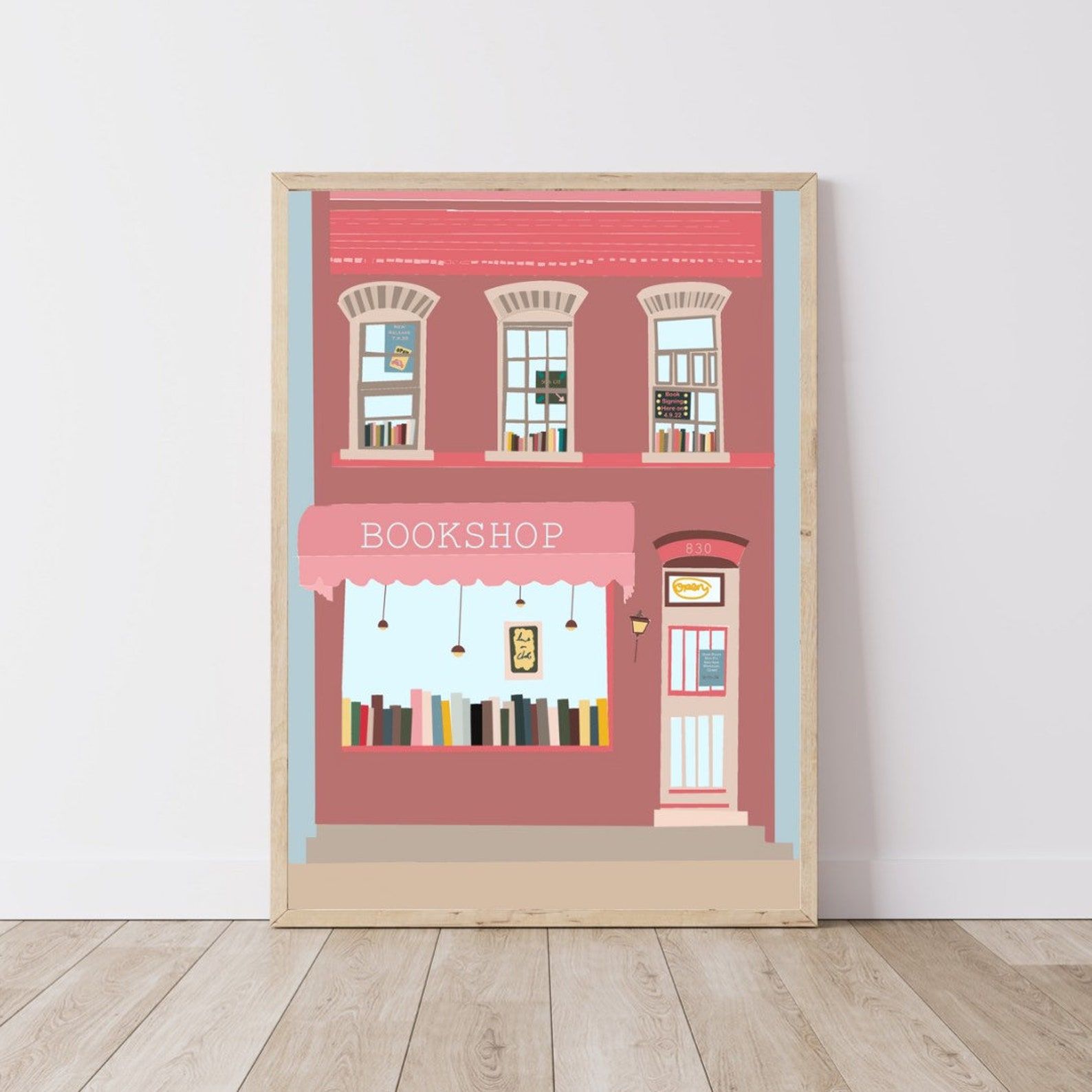 Print of a pink two story brick bookshop with glimpses of bookshelves in the windows.