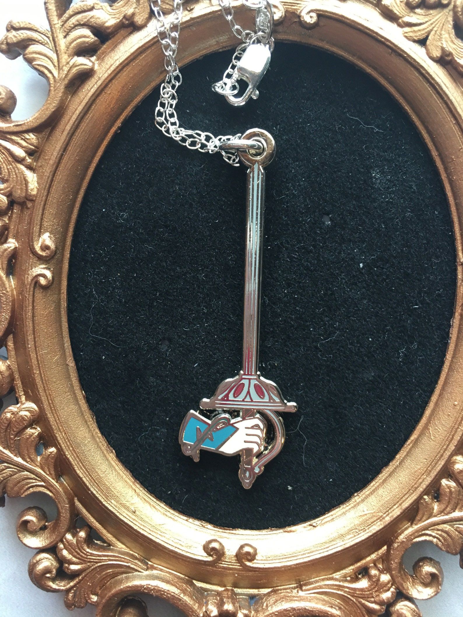 An enamel sword charm on a chain