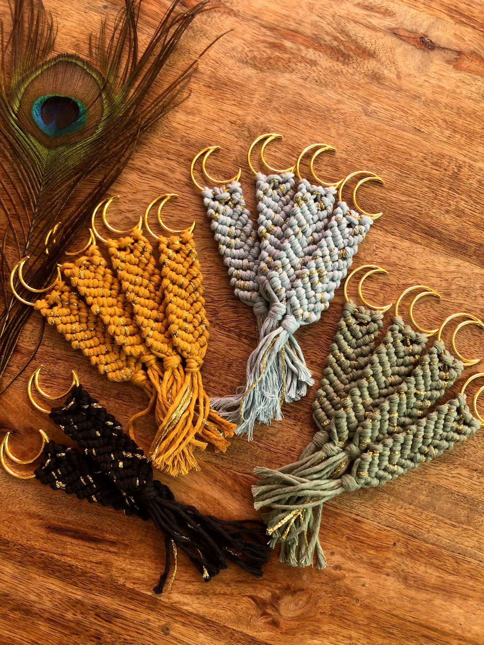 A collection of small macrame bookmarks in earthy colors, each featuring a half moon on it. 