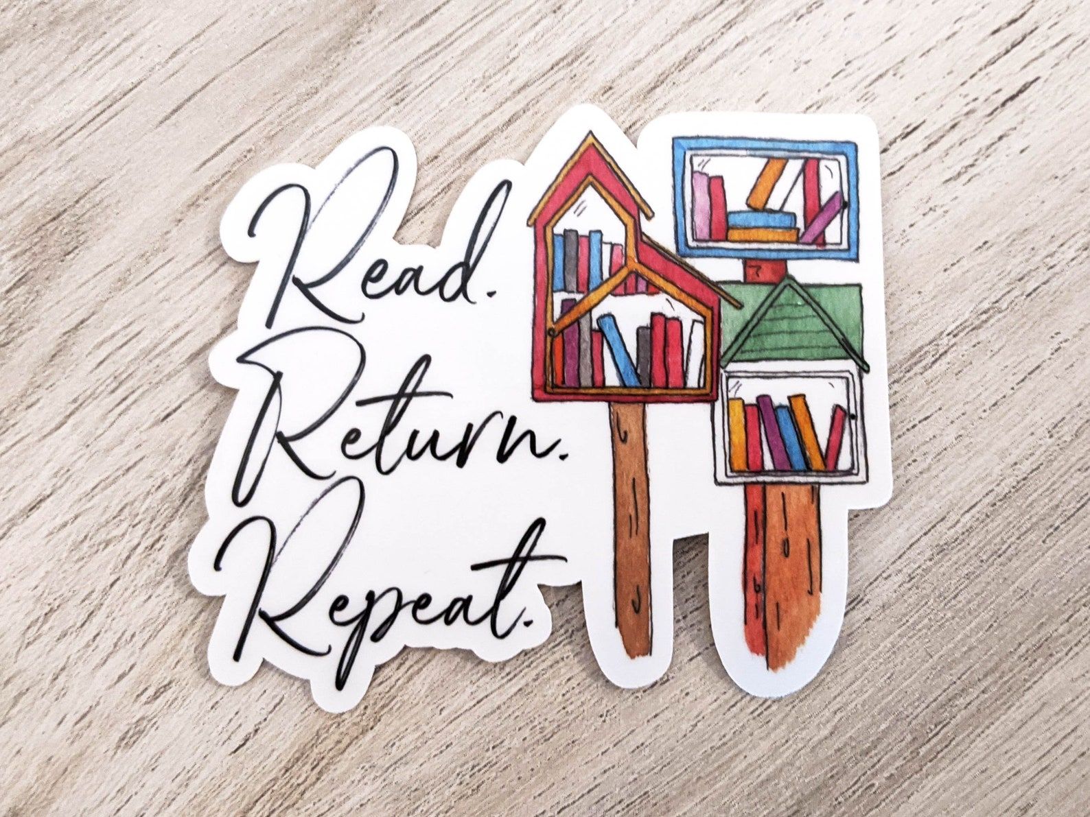 A vinyl sticker that reads "read, return, repeat" with three different LFL's.