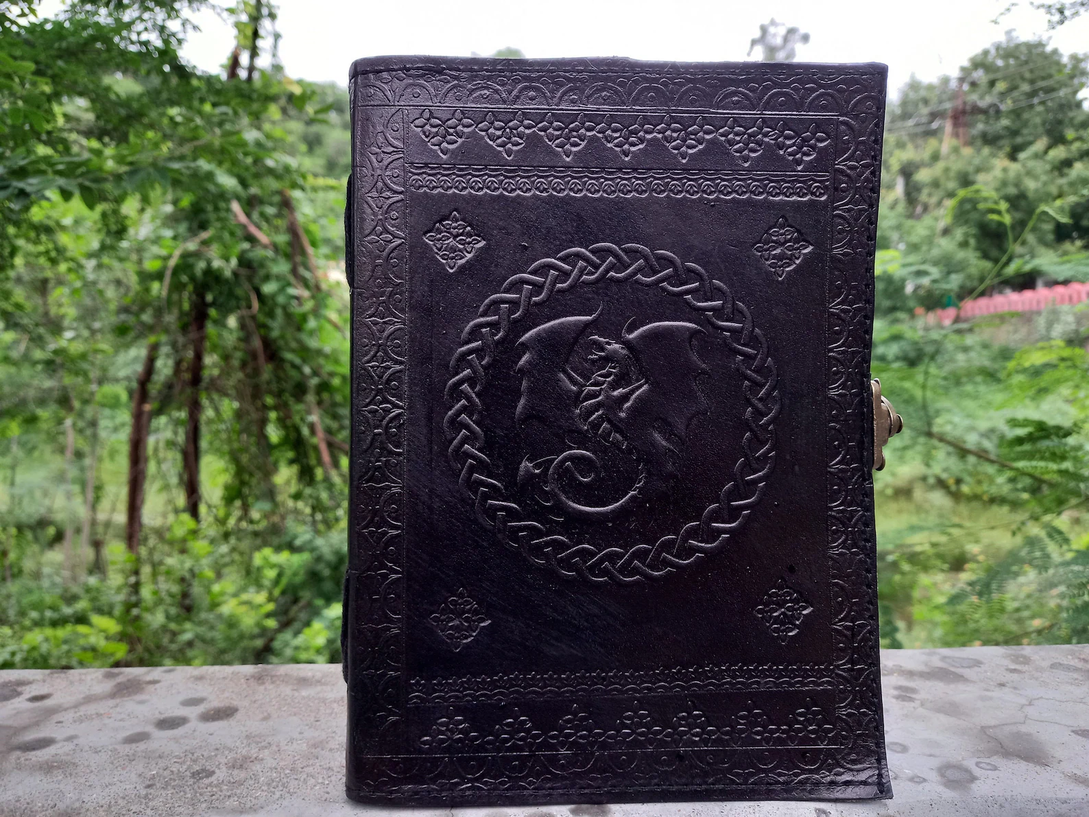 Etsy: A black notebook with a dragon in the middle.