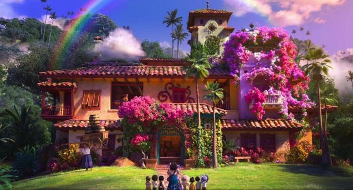 still frame from 2021 Disney animated film Encantp, showing a large house adorned in pink flowers with a rainbow in the sky above