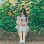 image of an asian woman reading outside