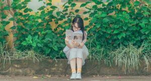 image of an asian woman reading outside