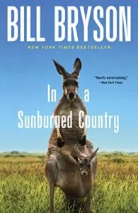 cover of In a Sunburned Country by Bill Bryson: photo of a kangaroo with a baby kangaroo in its pouch in a field of grass