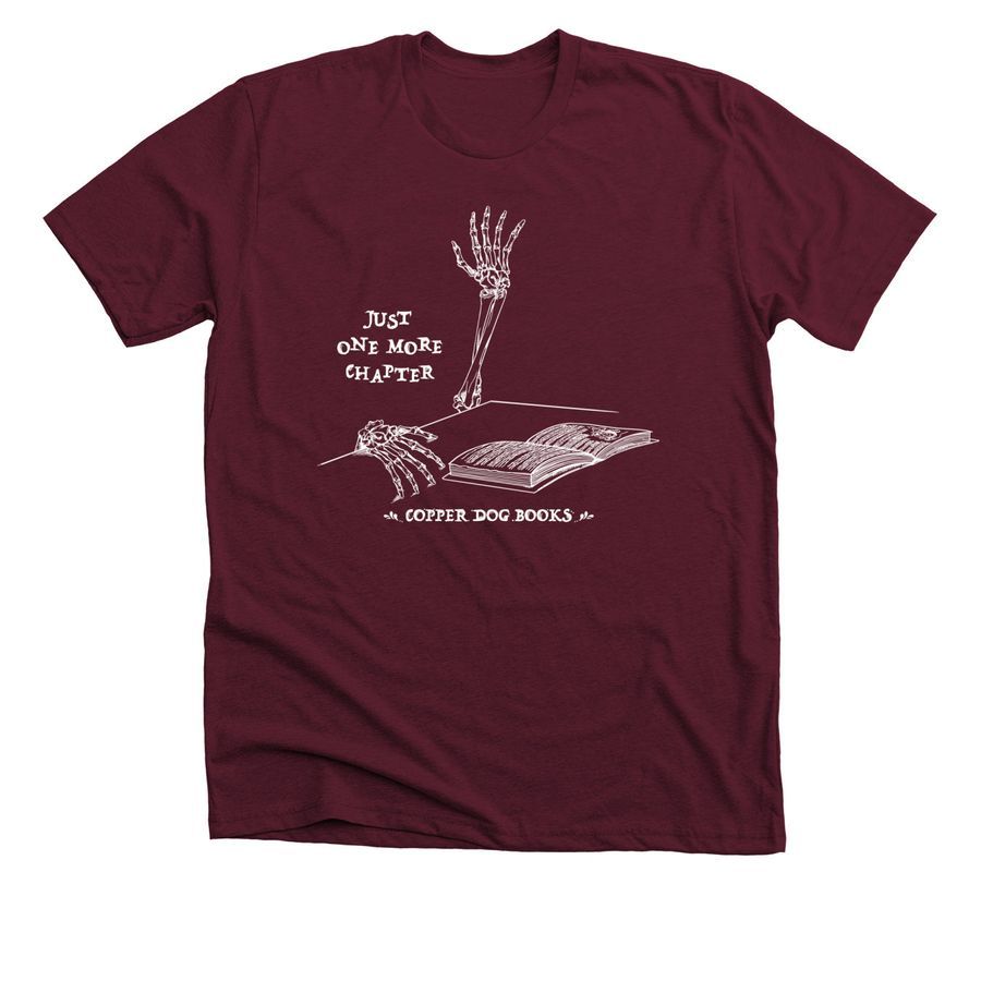 Maroon t-shirt featuring a skeletal hand reaching out to a book and the words "Just one more chapter"