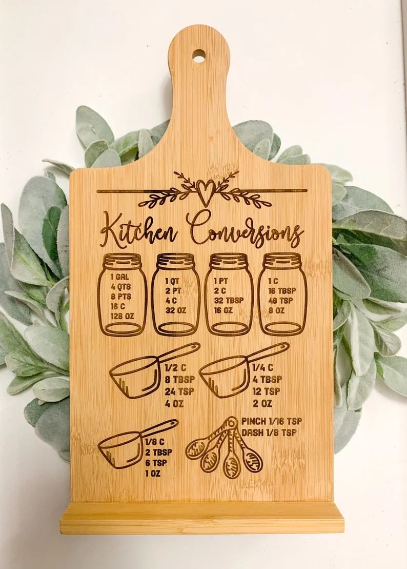 A wooden cookbook stand showing standard kitchen conversions between various units of measure.