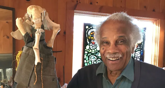 Ashley Bryan poses with his puppet